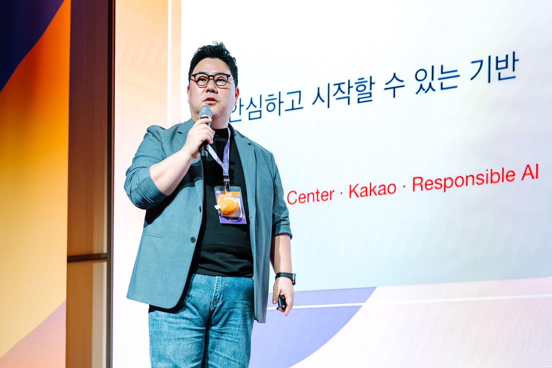 Man speaking on stage in front of a screen displaying "Kakao Responsible AI" and Korean text.