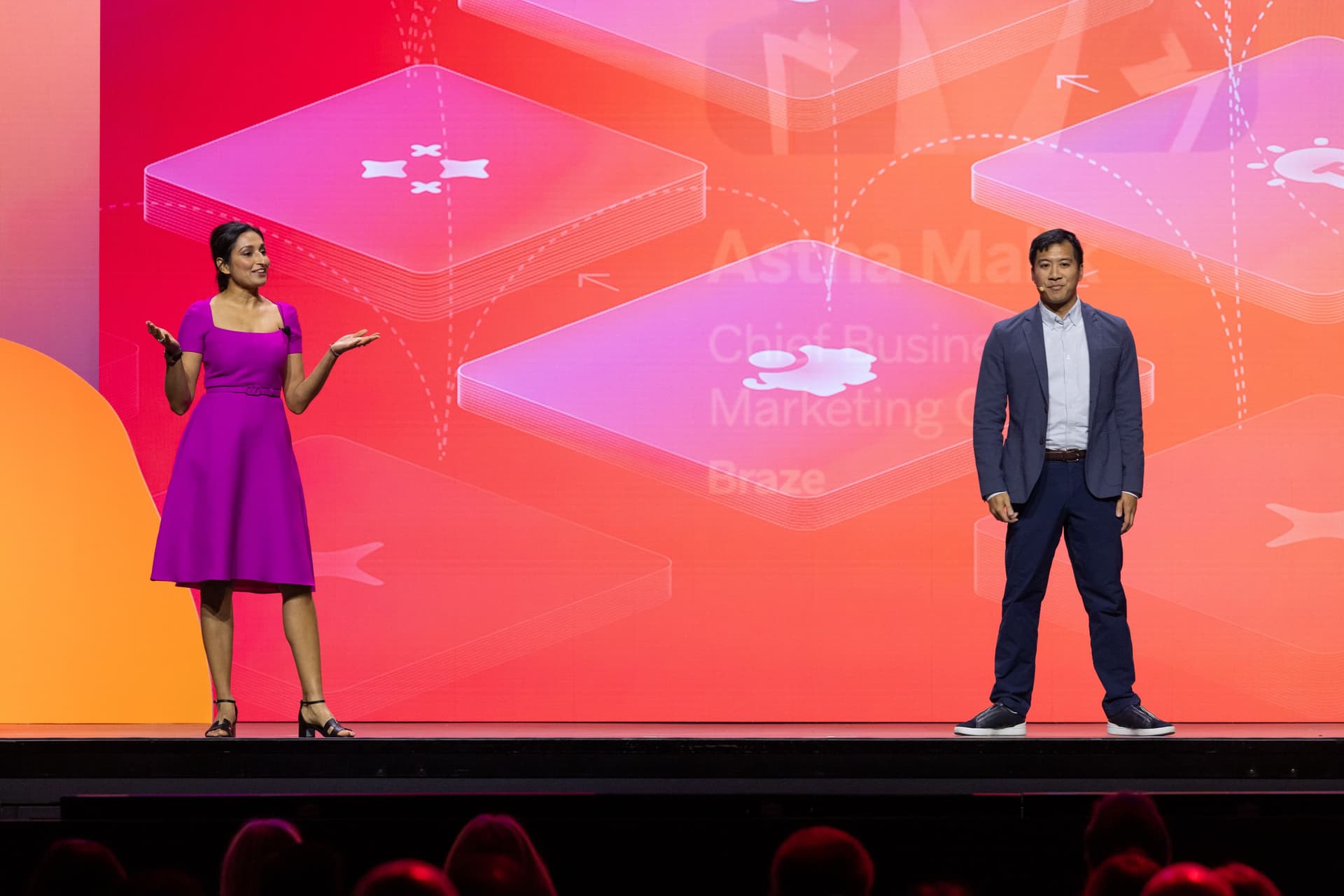 a man and a woman are standing on a stage giving a presentation .