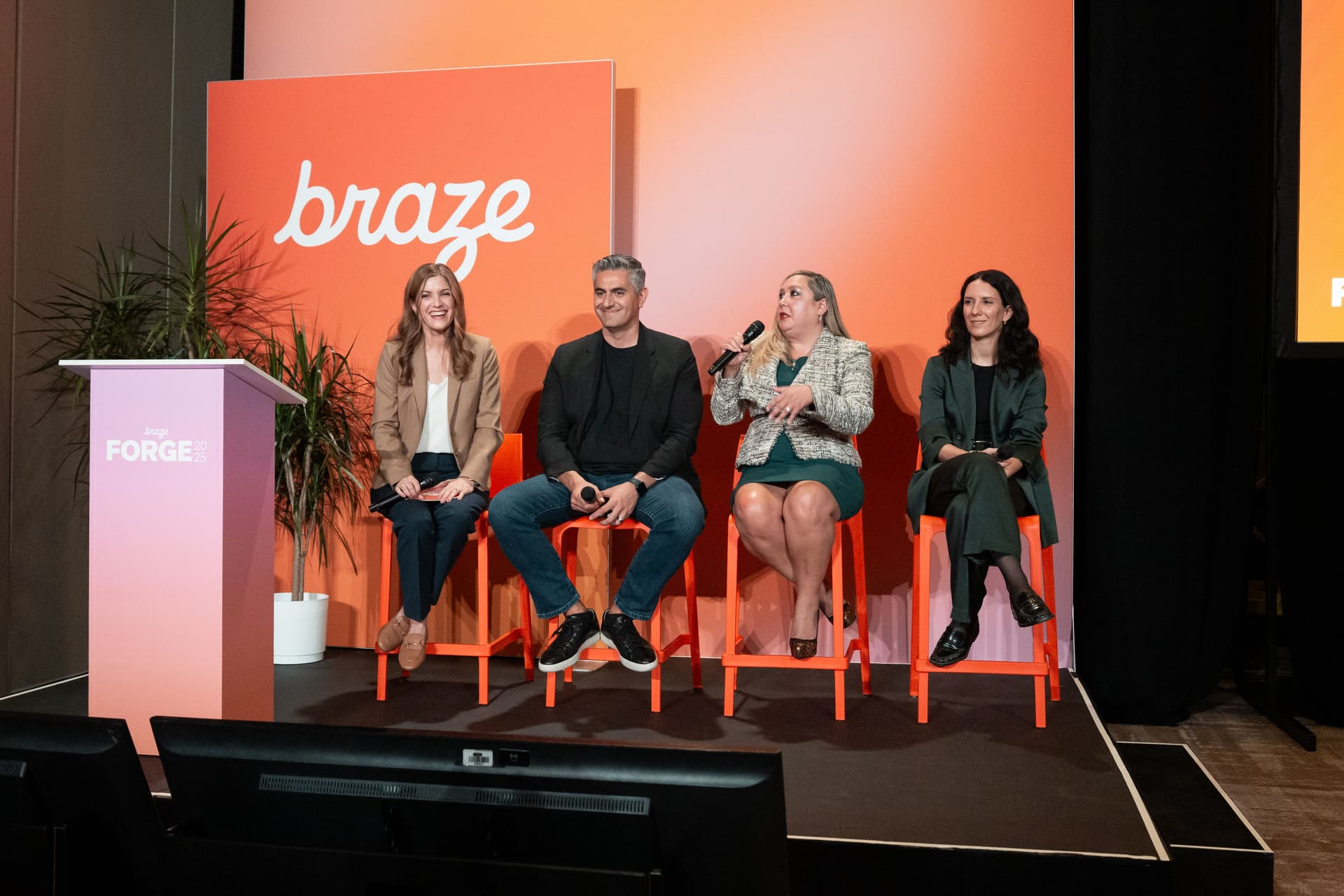 a group of people are sitting on a stage talking into microphones .