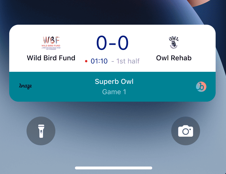 Une activité en direct sur l’écran de verrouillage d’un iPhone avec les scores de deux équipes. Les équipes Wild Bird Fund et Owl Rehab ont toutes deux un score de 0.